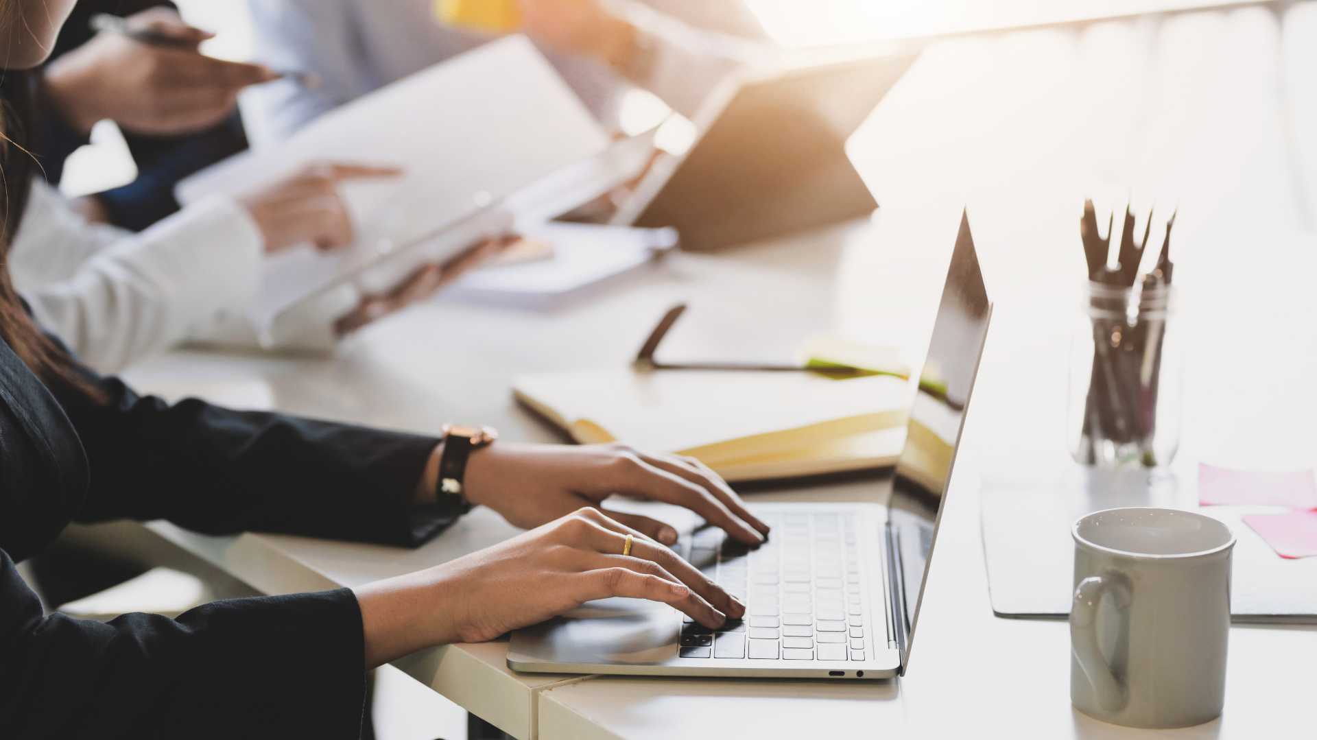 Officials reviewing records and data on a laptop — digital registries and service delivery
